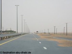 Bewegliche Sanddünen wandern in Abu Dhabi gelegentlich auch auf die Straßen.